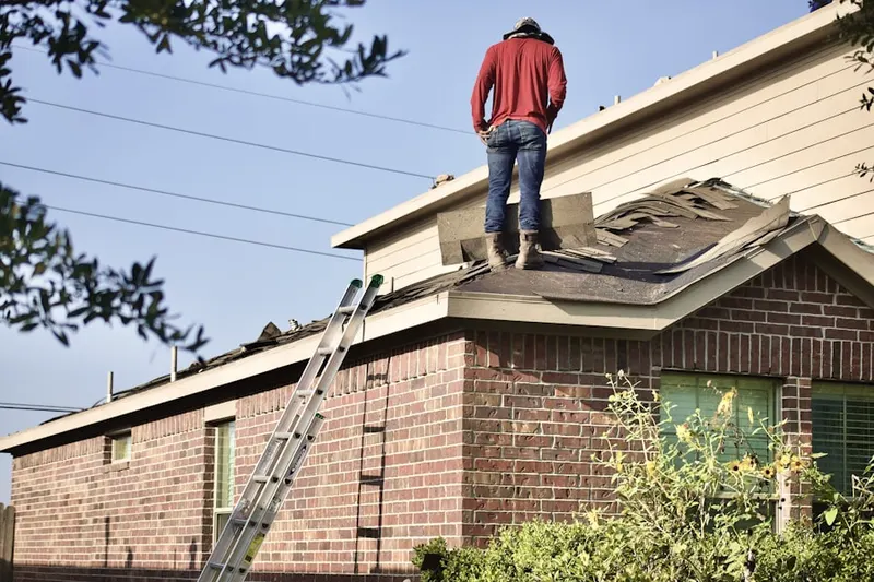 Professional roofer working on a residential roof in Nepaug